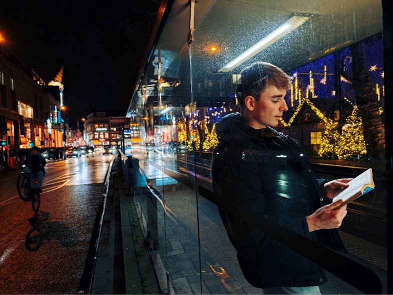 Foto eines jungen Mannes mit einem Buch in der Nacht